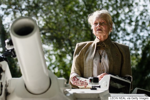 Fashion designer and environmental campaigner Vivienne Westwood rides on top of an armored personnel carrier (APC) towards the home of British Prime Minister David Cameron's home in Chadlington, Oxfordshire on September 11, 2015 to highlight the Government's plan to use hydraulic fracturing (fracking) to recover fossil fuels from the ground in regions of the north of England. The vehicle parked outside the prime minister's home before a group of protestors in gas masks led chants and held banners calling for the Government to change it's policy on the controversial plans.  AFP PHOTO / LEON NEAL        (Photo credit should read LEON NEAL/AFP/Getty Images)
