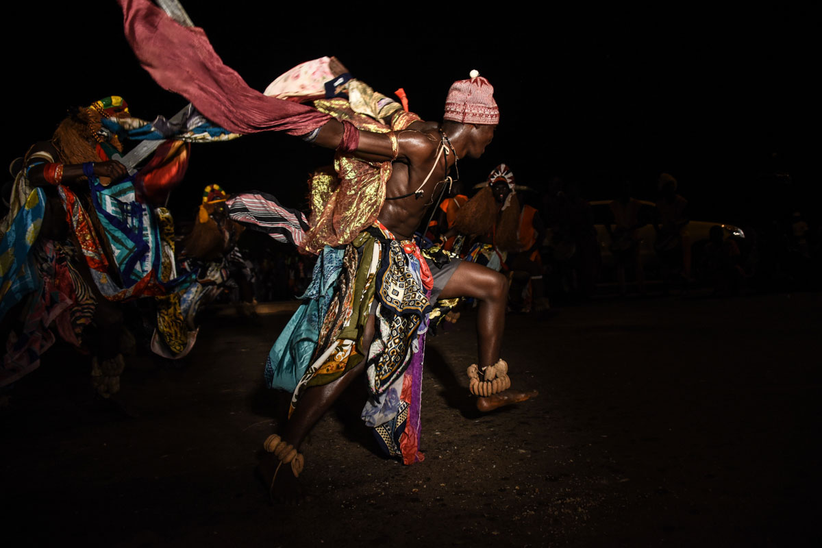 A group in vividly coloured costumes performs a dance from the Bijagos ethnic group in Bissau, as they compete in carnival. [Ricci Shryock/Al Jazeera]