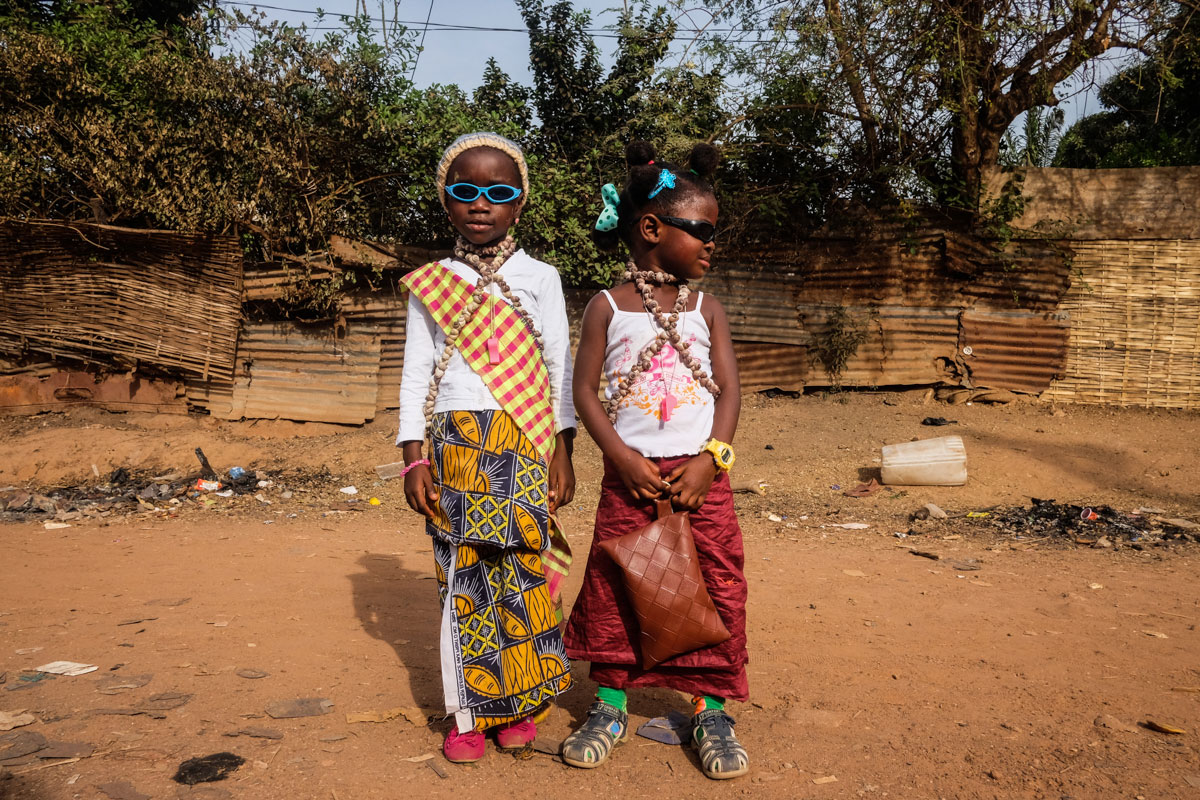 Two girls from the Bijaos ethnic group  show off their carnival outfits and shell necklaces. [Ricci Shryock/Al Jazeera]