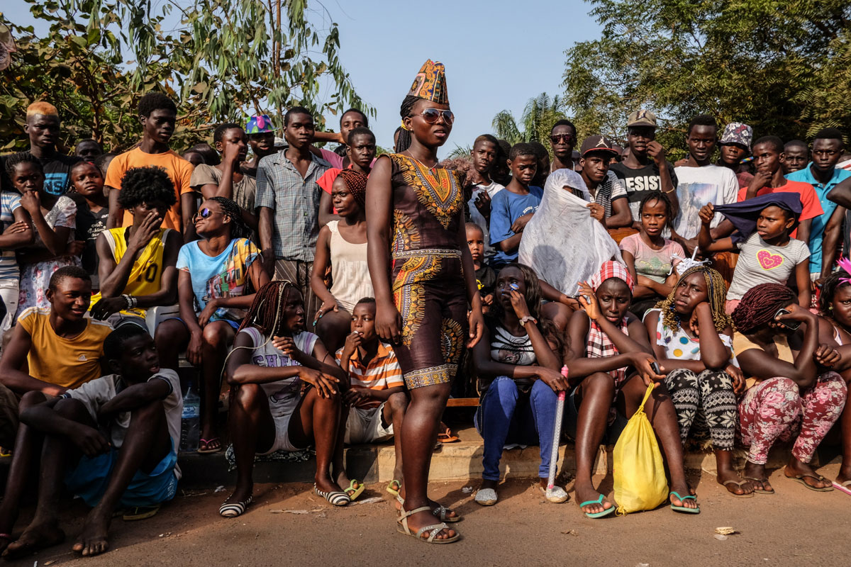 Spectators line up to watch the first day of carnival competition which features traditional dances and songs from different parts of Guinea Bissau. [Ricci Shryock/Al Jazeera]